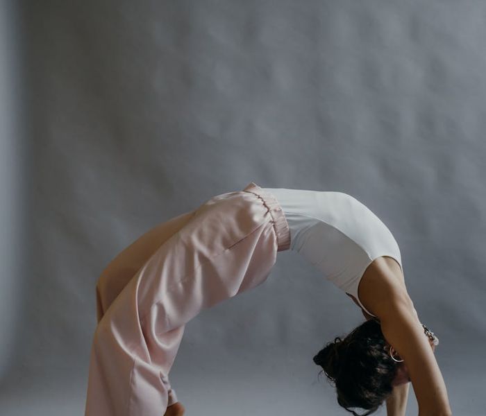 Woman performing a gentle stretching yoga pose, focusing on body awareness.